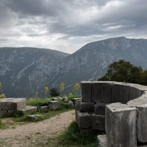 A picture of antiquities in Delphi with a breathtaking mountain backdrop.