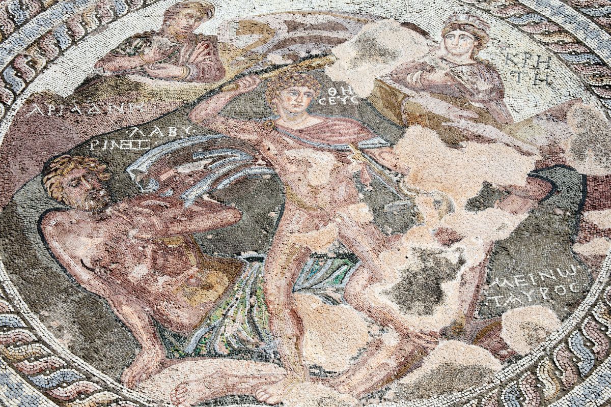 The image depicts a mosaic showing Theseus slaying the Minotaur, with other figures observing the scene.