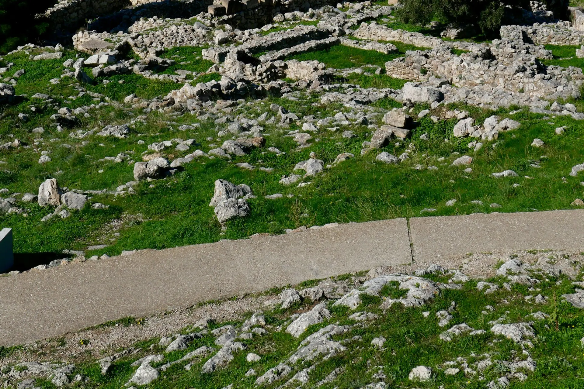 Ancient ruins on a grassy hill at the archaeological site of Mycenae, Greece